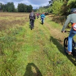 Eine Gruppe von wissenschaftlern fahren mit E-Mountainbikes über eine grüne Wiese | Foto: Cosmic Sense Konsortium