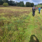 Eine Gruppe von wissenschaftlern fahren mit E-Mountainbikes über eine grüne Wiese | Foto: Cosmic Sense Konsortium