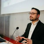 Ein Mann im schwarzen Jacket am Rednerpult