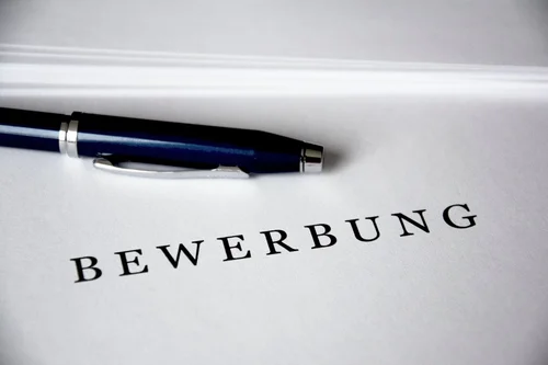 Stift liegt auf Blatt, das mit Bewerbung beschriftet ist
