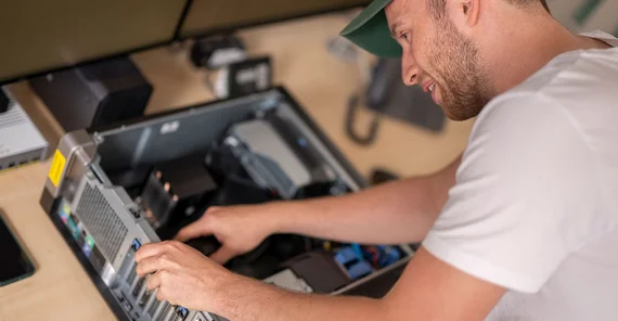 Person arbeitet an aufgeschraubtem PC-Tower