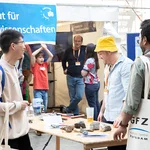 Mehrere Personen an einem Tisch mit Steinen