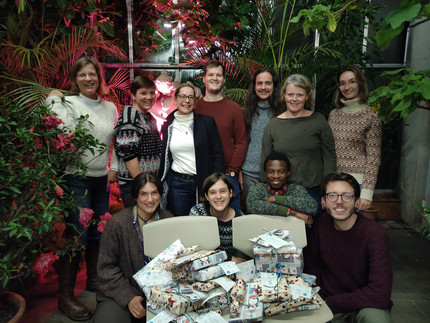 our working standing in front of christmas packages gifts