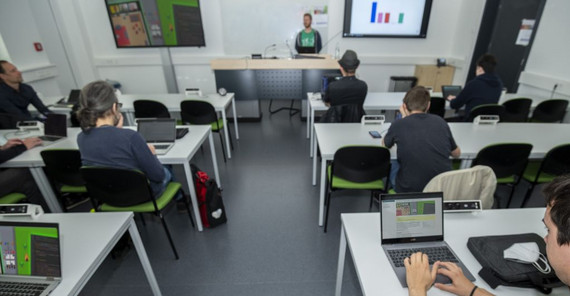 Menschen sitzen vor Laptops in einem Seminarraum. Das Foto hat Thomas Roese gemacht.