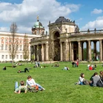 This image shows students on the large yard at the Neues Palais Campus. 