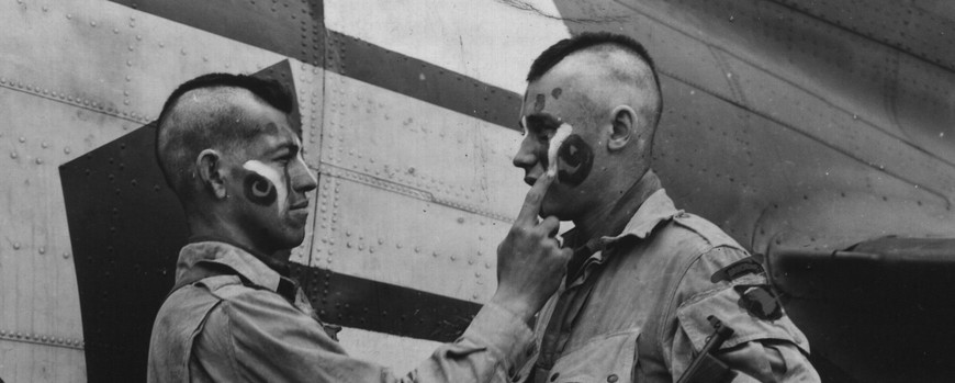 Zwei Fallschirmjäger der 101. US-Luftlandedivision tragen in letzter Minute Kriegsbemalung auf, Juni 1944, NARA, 5957435