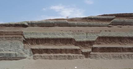 Konjugierte Abschiebungen in nahezu idealer Ausrichtung zur Dehnung bilden einen kleinen Graben in miozänen Sediment-Schichten, die Erosionsprodukte aus dem Elburs-Gebirge sind.