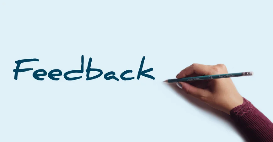 Image: “Feedback” logo, with a hand to the right holding a green Writing Assistance Program pen.