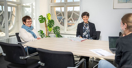 Prof. Dr. Barbara Höhle (links) und Dr. Nina Khan (rechts) am Tisch mit Interviewpartnerin Dr. Jana Scholz. Das Foto ist von Thomas Roese