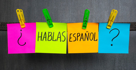 vier Post-its, die mit Wäscheklammern an einer Leine befestigt sind, auf denen steht: "hablas espanol?"