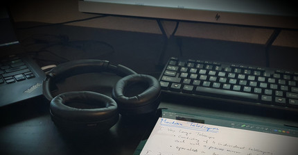 desk with tablet in front of PC screen