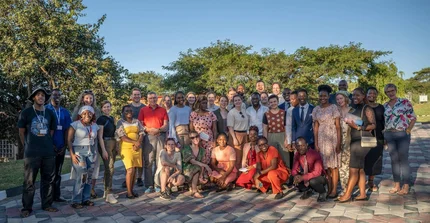 Gruppenbild von Studierenden der Universität Potsdam und der Africa University in Simbawe stehen gemeinsam unter blauem Himmel.