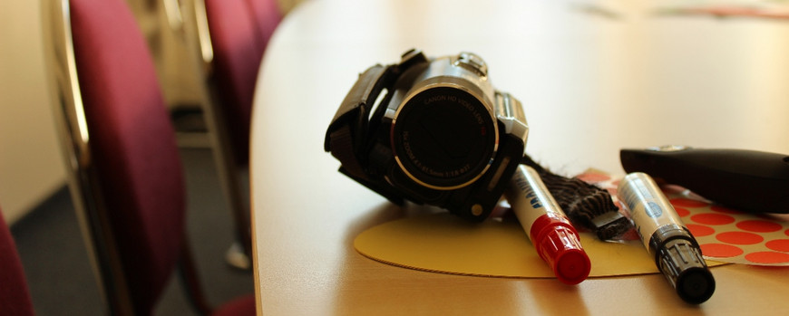 Camcorder mit Stiften und Material auf einem Tisch liegend