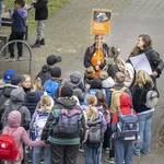 Kindergruppe und zwei Erwachsene mit einem Schild