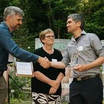 Drei Menschen bei einer Preisverleihung