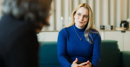 Tina Kowalzik im Interview auf einem Sofa sitzend.