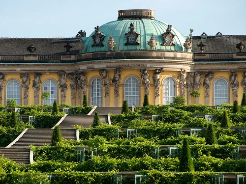 Historisches Gebäude mit gelber Außenfassade und Weinbergterrasse