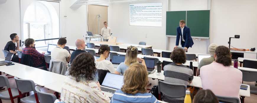 Blick in einen Seminarraum richting Tafel, vor der Professor Neitzel steht