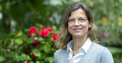 Prof. Dr. Anja Linstädter im Portrait vor blühenden Pflanzen.