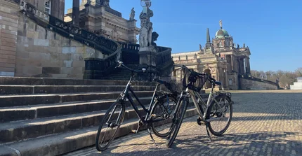 Zwei Fahrräder stehen vor der Freiteppe vor den Communs am Campus Am Neuen Palais.