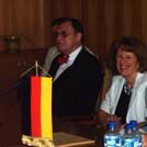 Prof. Dr. Dr. Detlev W. Belling M.C.L. (U. of Ill.) (l), Frau Prof. Dr. Eva Jakab (m), Prof. Dr. Dorothea Assmann (r) sitzen gut gelaunt bei der Zeugnisfeier 2008 in Szeged zusammen am Tisch und hören einer Rede zu.