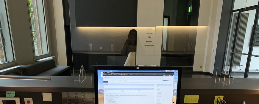 Schreibtisch an einem Empfang mit zwei Rechnern darauf
