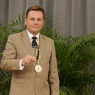 Moderatorin Kristina Tschesch und Präsident Günther halten jeweils ein Sektglas in der Hand.