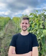 a man is standing in the landscape, in front of plants