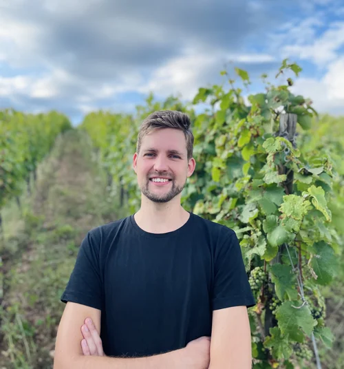 a man is standing in the landscape, in front of plants