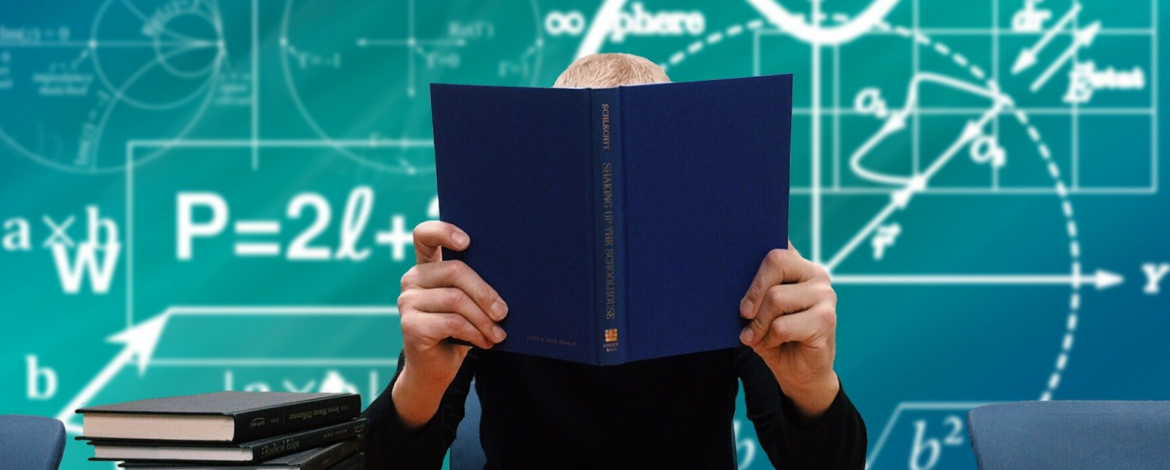 Doctoral student sitting behind a book - Doctorates at the UP