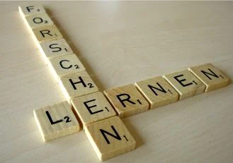 Das Bild zeigt Forschen und Lernen als Buchstaben gekreuzt