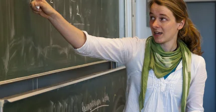 Lehrerin zeigt auf Tafel