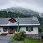 Summer scene with snow in front of a cosy hut in Zwieselstein