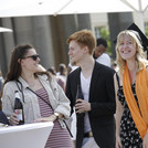 Das Bild zeigt eine Absolventin der Humanwissenschaftlichen Fakultät mit zwei Bekannten.