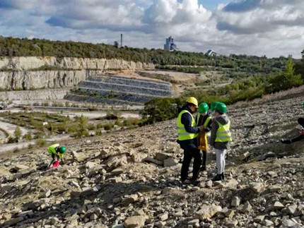 Group of children searching for fossiles guided by mineralogist Lisa Sieg 