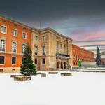 Seltenes Farbenspiel: Das Unihauptgebäude in Griebnitzsee ruht im Winterschlaf vor einem farbigen Himmel.