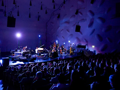 Bühne mit Musikern in dunklem Theatersaal