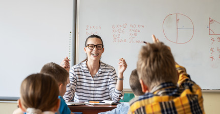 Lehrerin freut sich über die rege Beteiligung der Schüler, die sich melden.