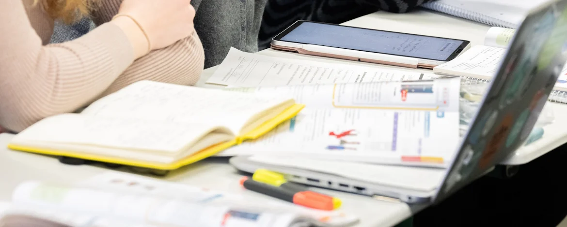 Arbeitsplatz mit Schreibmaterialien und Laptop - 