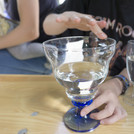 Mit einem gefüllten Wasserglas Töne erzeugen