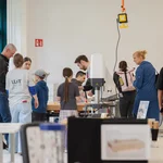 Mehrere Personen in einer Werkstatt.