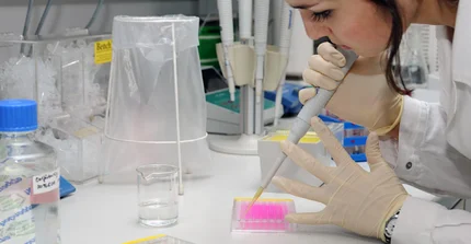Studierende mit Pipette an Reagenzglas im Labor