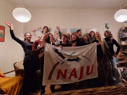 Mehrere Personen halten ein Banner