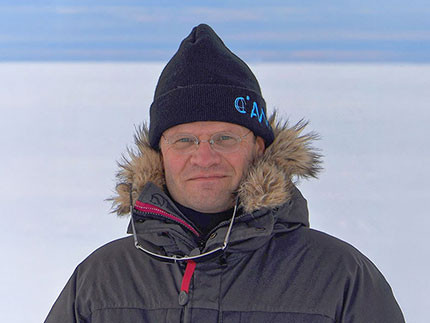 Prof. Markus Rex in thick winter clothing. In the background, a barren, icy expanse.