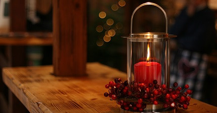 rote Kerze im Windlicht auf einem Tisch
