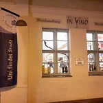 Aussenfassade der Weinhandlung „In Vino“ mit Beachflag von „Uni findet Stadt“