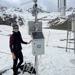 Field site Weisssee: a scientist standing next to a newly installed CRNS sensor in an alpine landscape with snow | Photo: Cosmic Sense Consortium