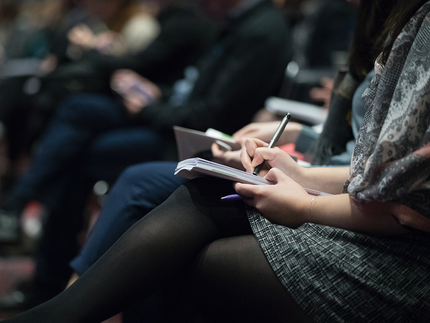 Stuhlreihen mit Personen auf einer Konferenz