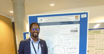 Alain Bapolisi in front of his Poster