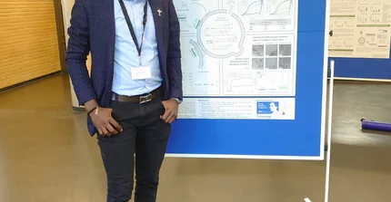 Alain Bapolisi in front of his Poster